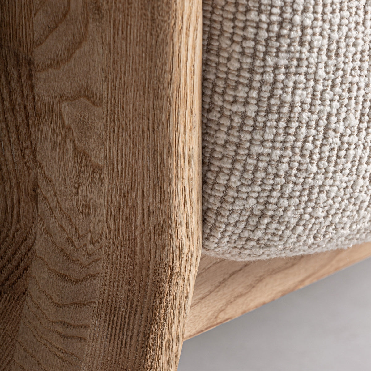 Detalle inferior de la unión entre el tapizado y la estructura de madera del sillón Nara