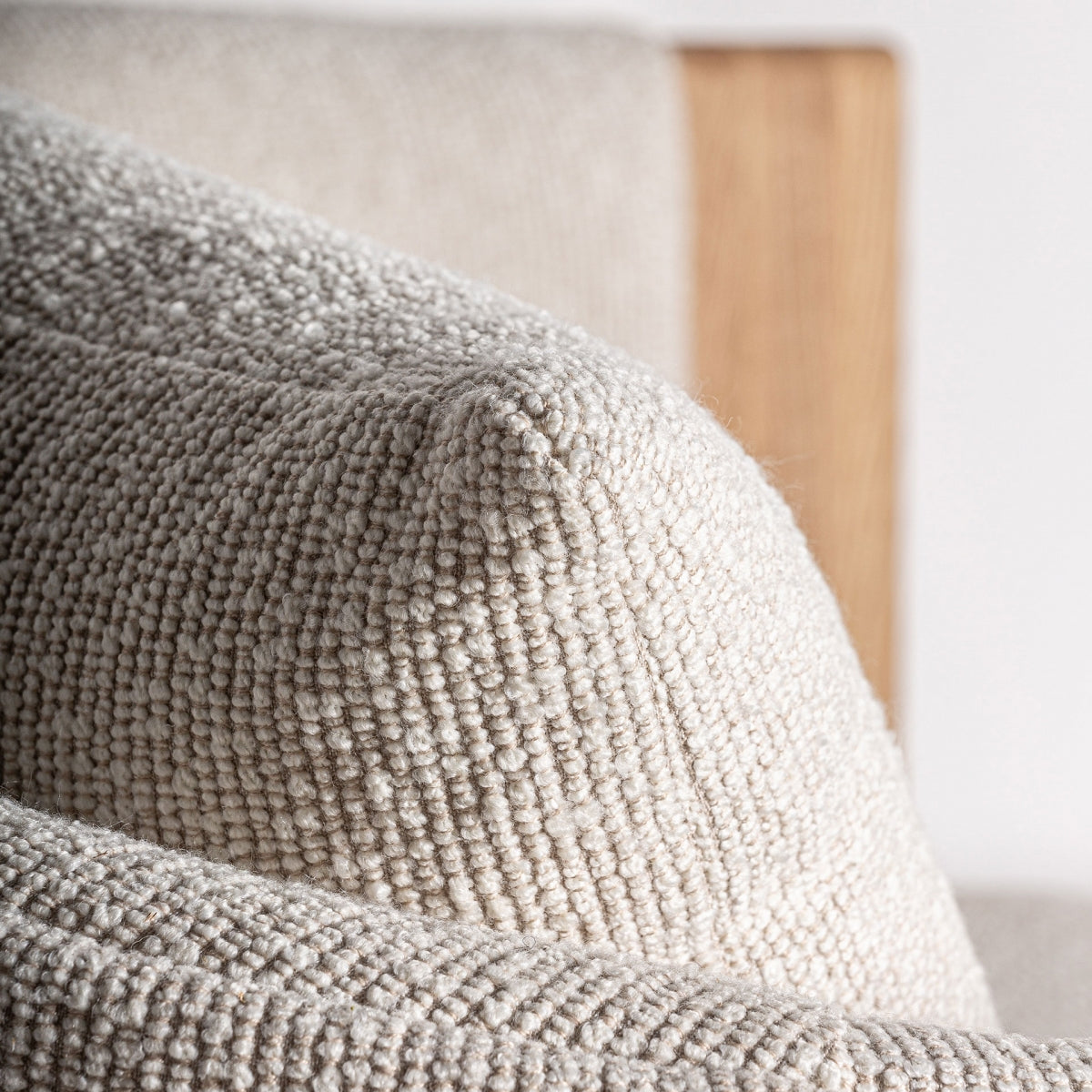 Primer plano del cojín desenfundable del sillón Nara, textura bouclé en tono beige cálido