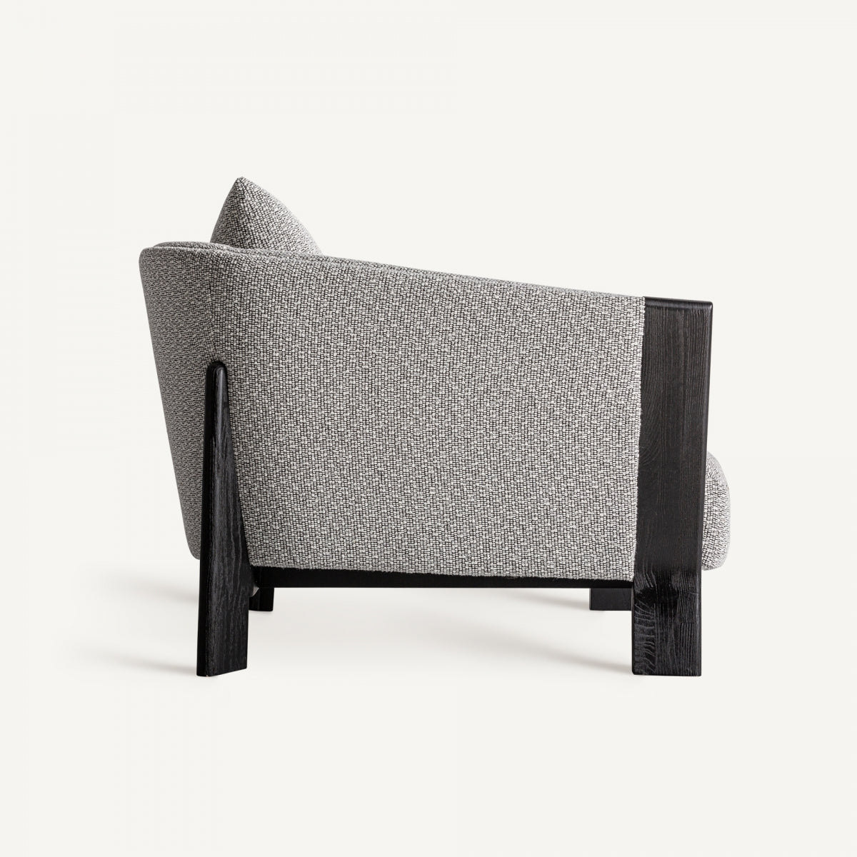 Vista lateral del sillón Nara con estructura de madera negra y formas ergonómicas