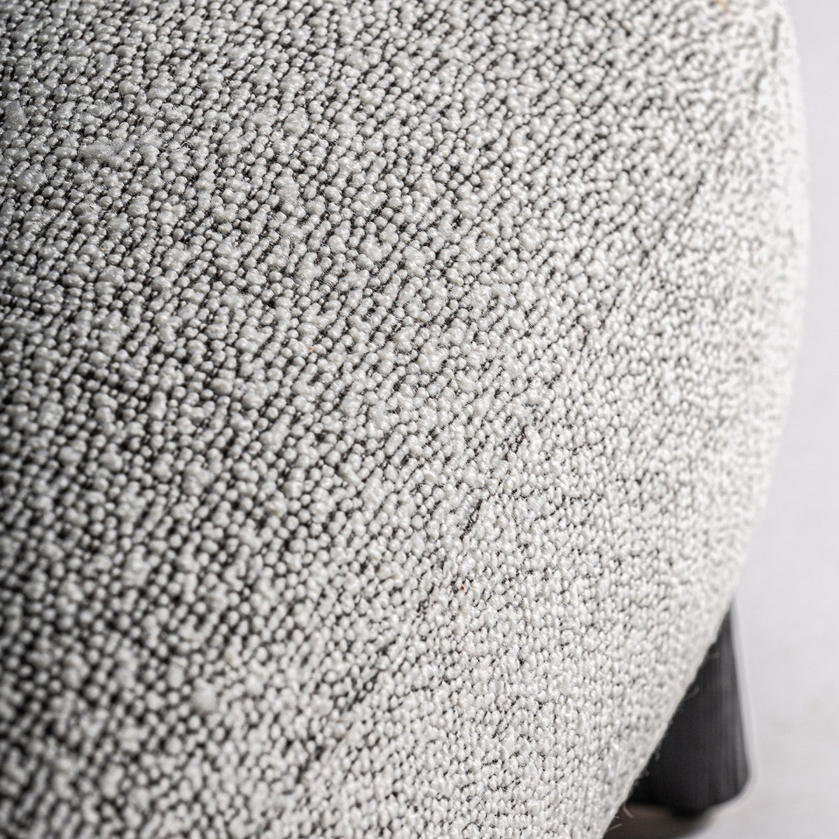 Detalle del tejido bouclé gris del sillón Nara mostrando su textura densa y suave