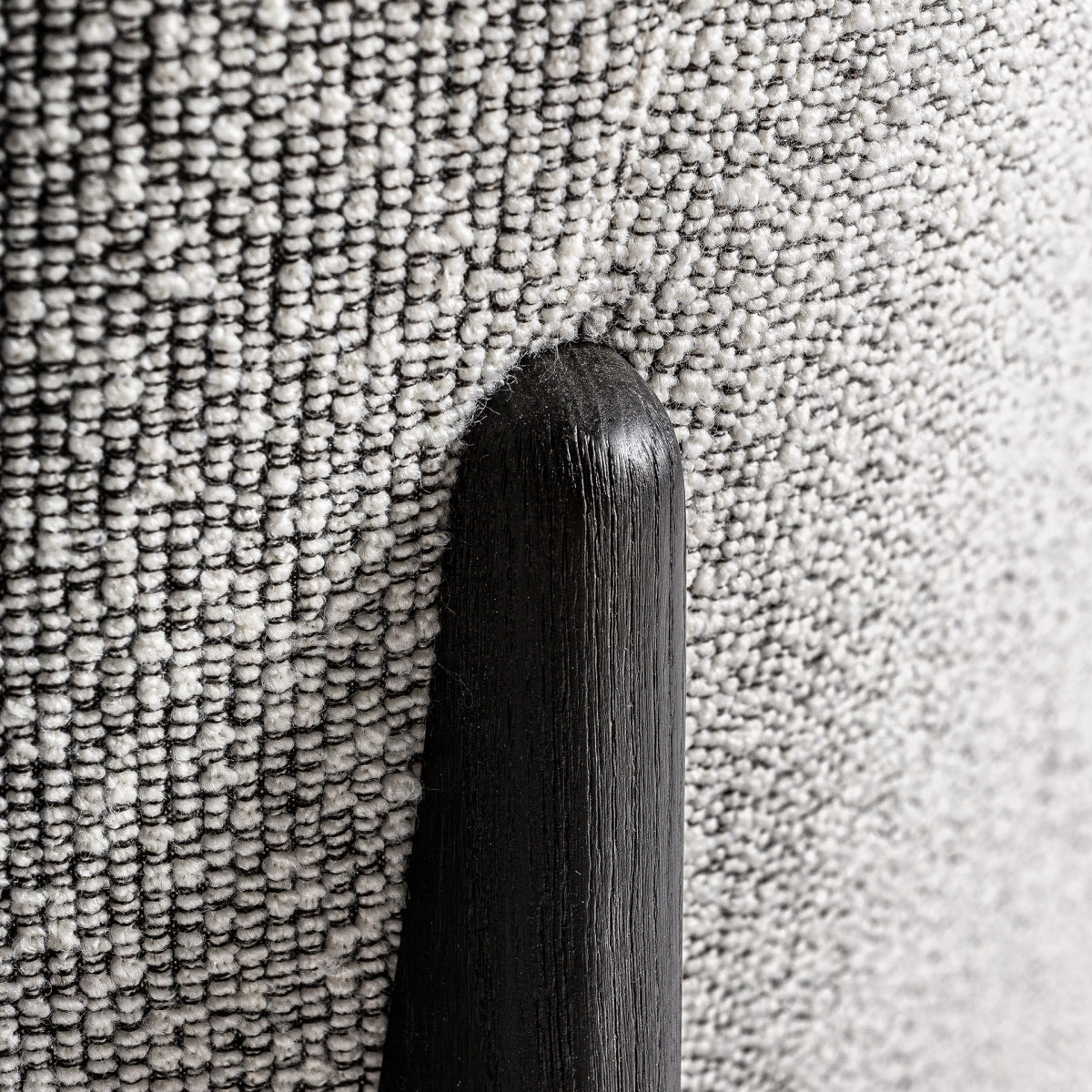 Detalle del soporte trasero redondeado del sillón Nara en madera negra mate y líneas orgánicas