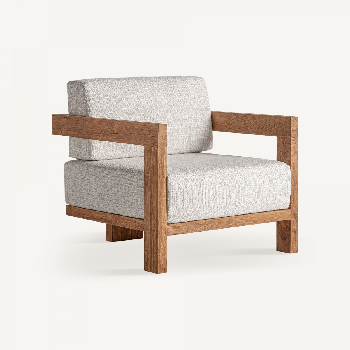 Vista en ángulo del sillón de madera maciza con cojines tapizados en tejido crudo – diseño cálido boutique interiorismo vical