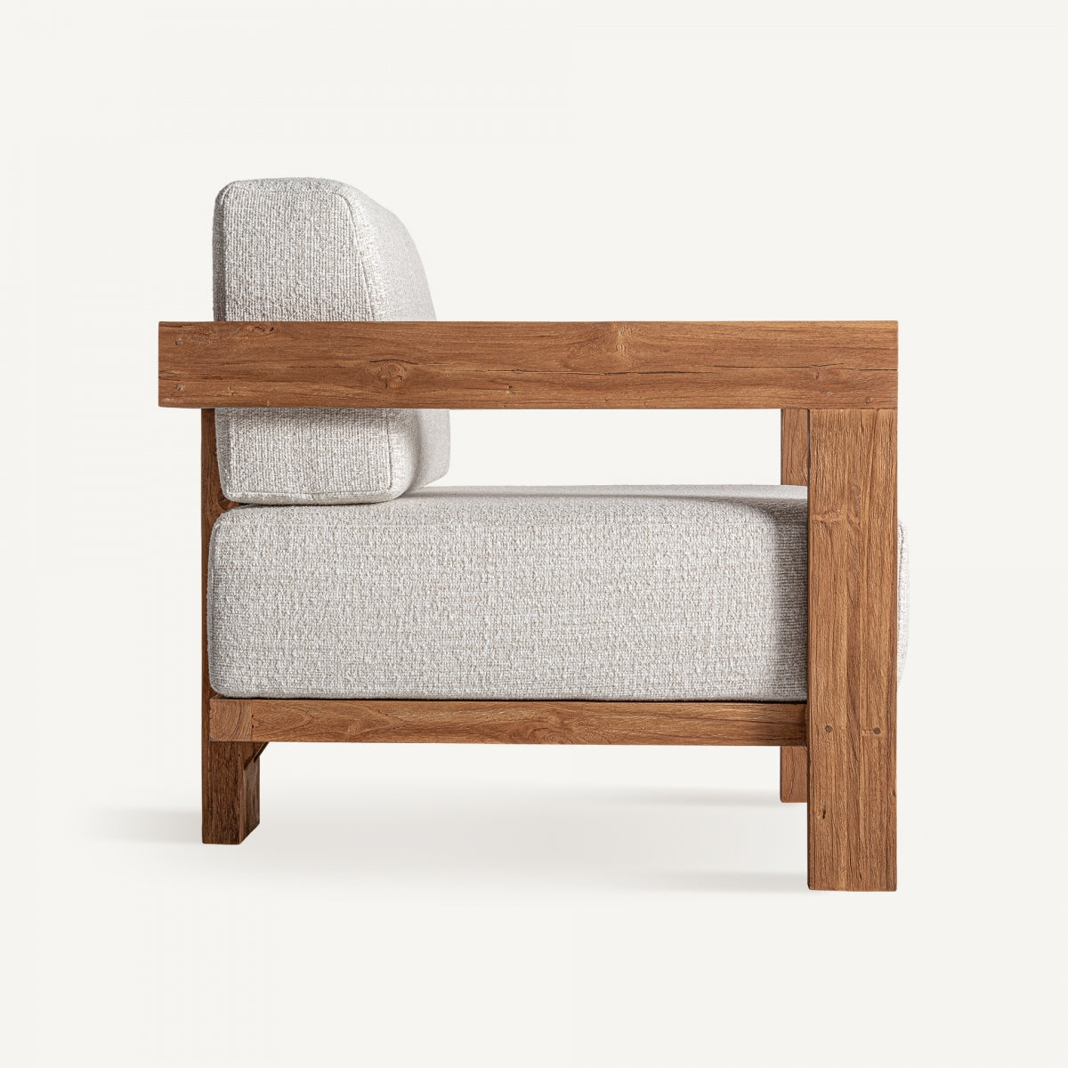 Vista lateral del sillón con brazos rectos de madera natural – mueble sobrio y estructurado boutique interiorismo vical