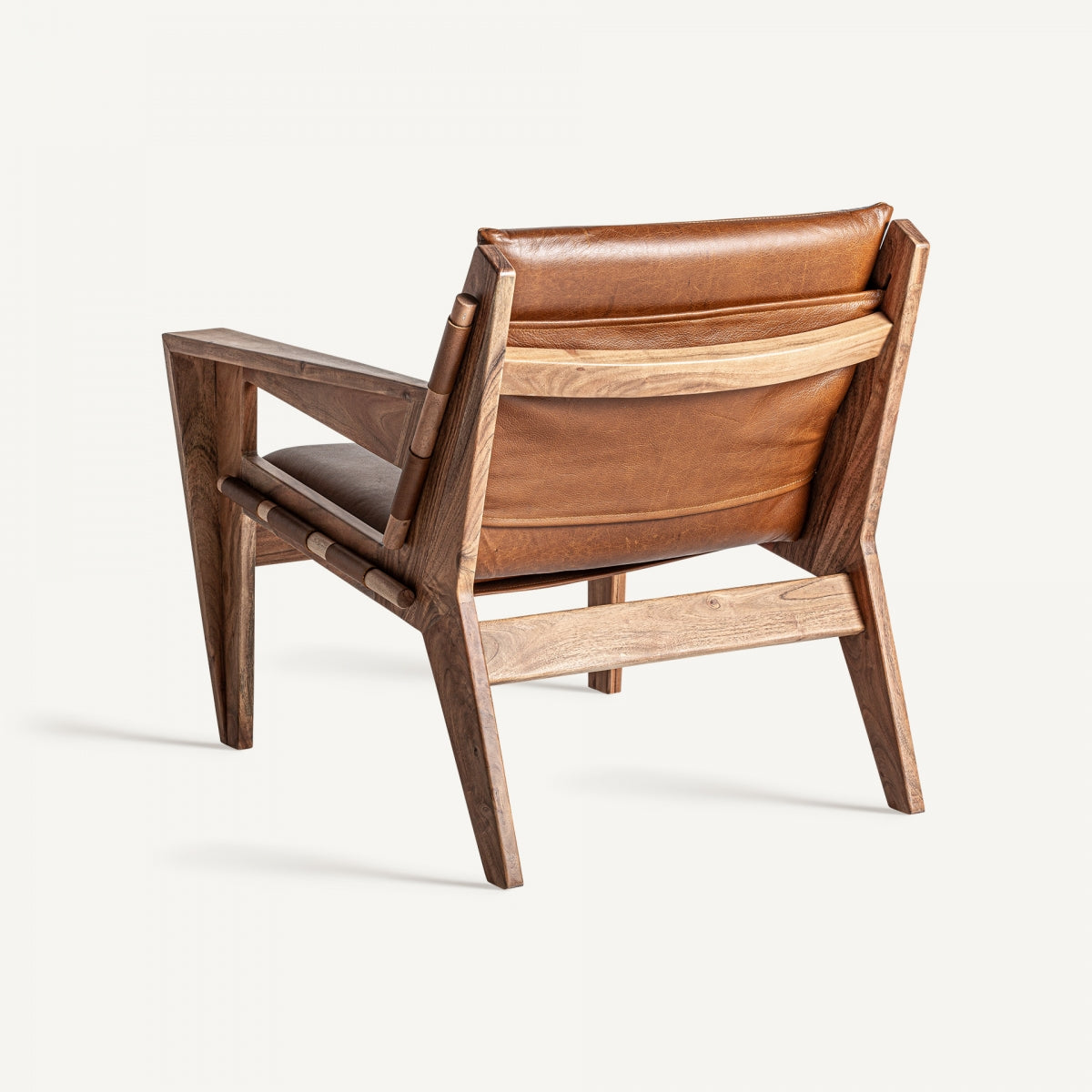 Vista trasera del sillón MELLE, respaldo de cuero y estructura visible en madera natural
