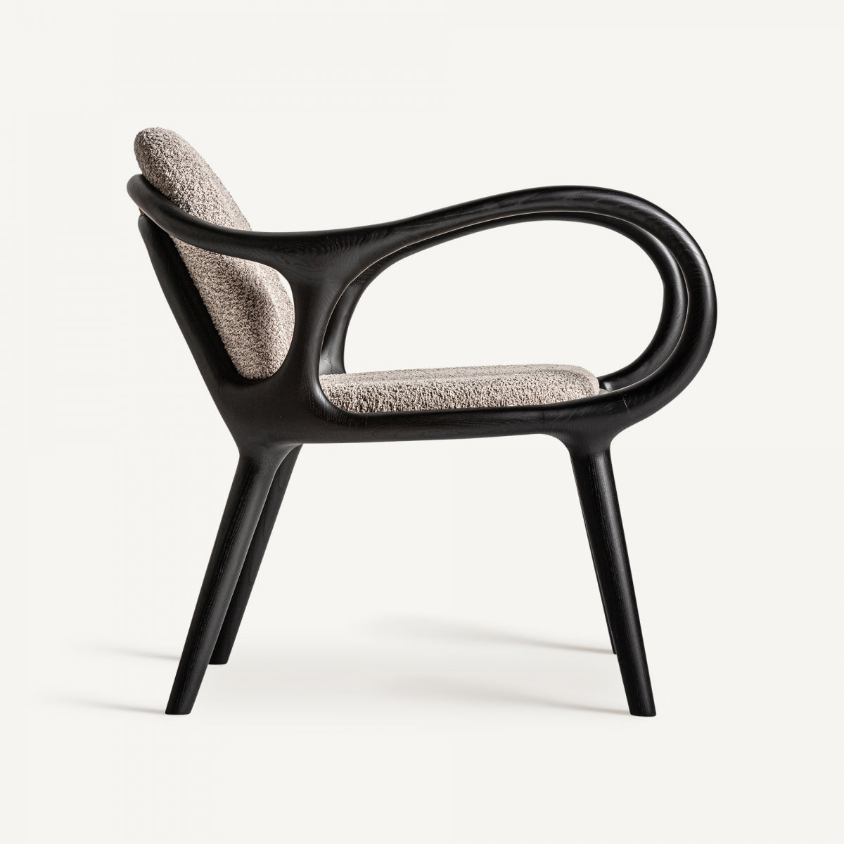 Vista lateral del sillón con estructura de madera curva y asiento tapizado en tejido cálido