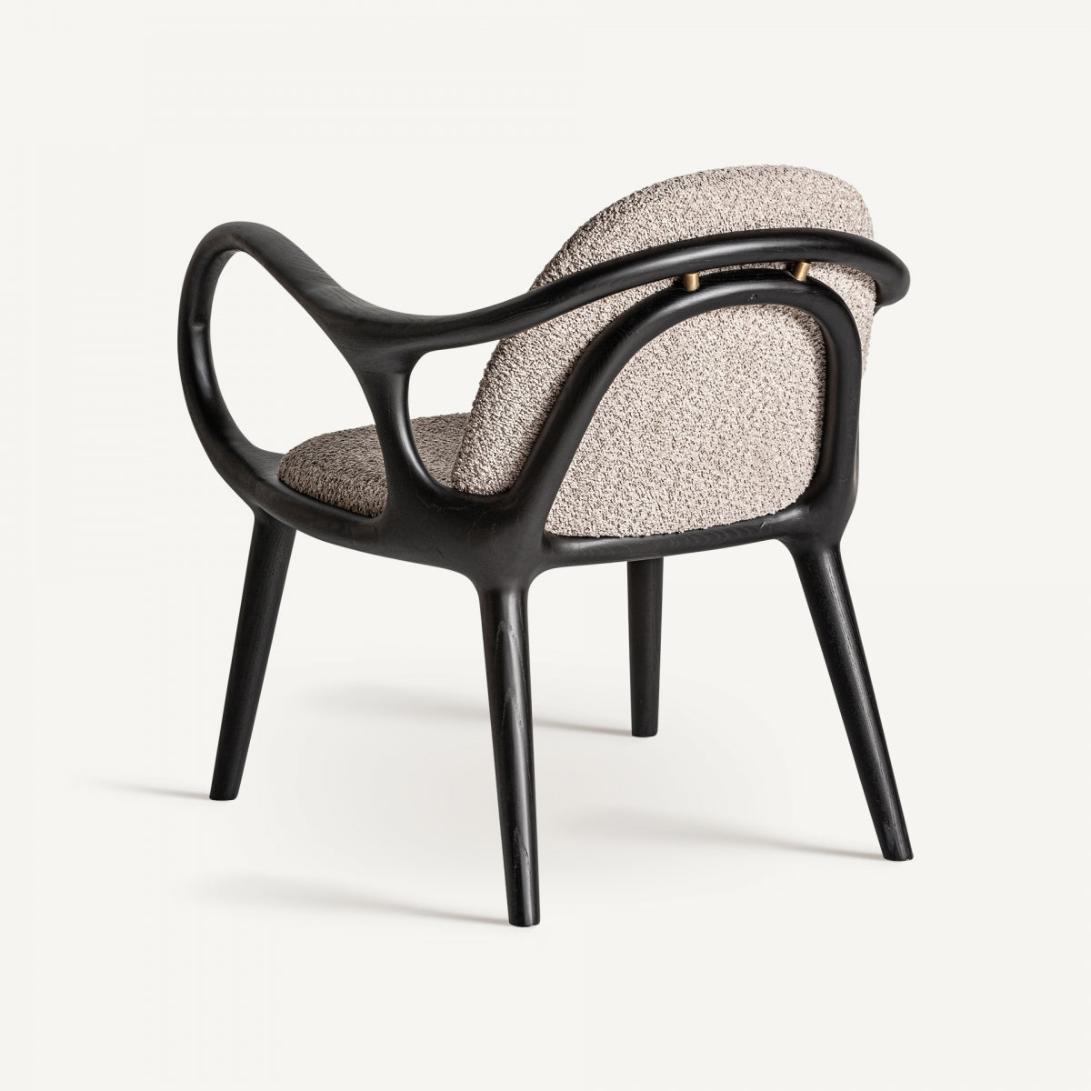Vista trasera del sillón Herten con respaldo acolchado y detalles metálicos en el anclaje del respaldo