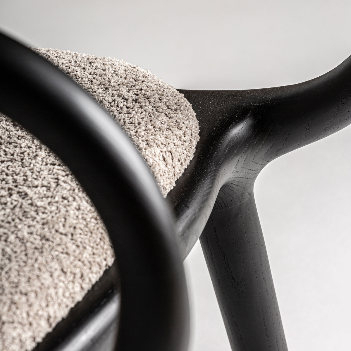 Unión suave entre estructura de madera y asiento tapizado del sillón Herten, vista de detalle