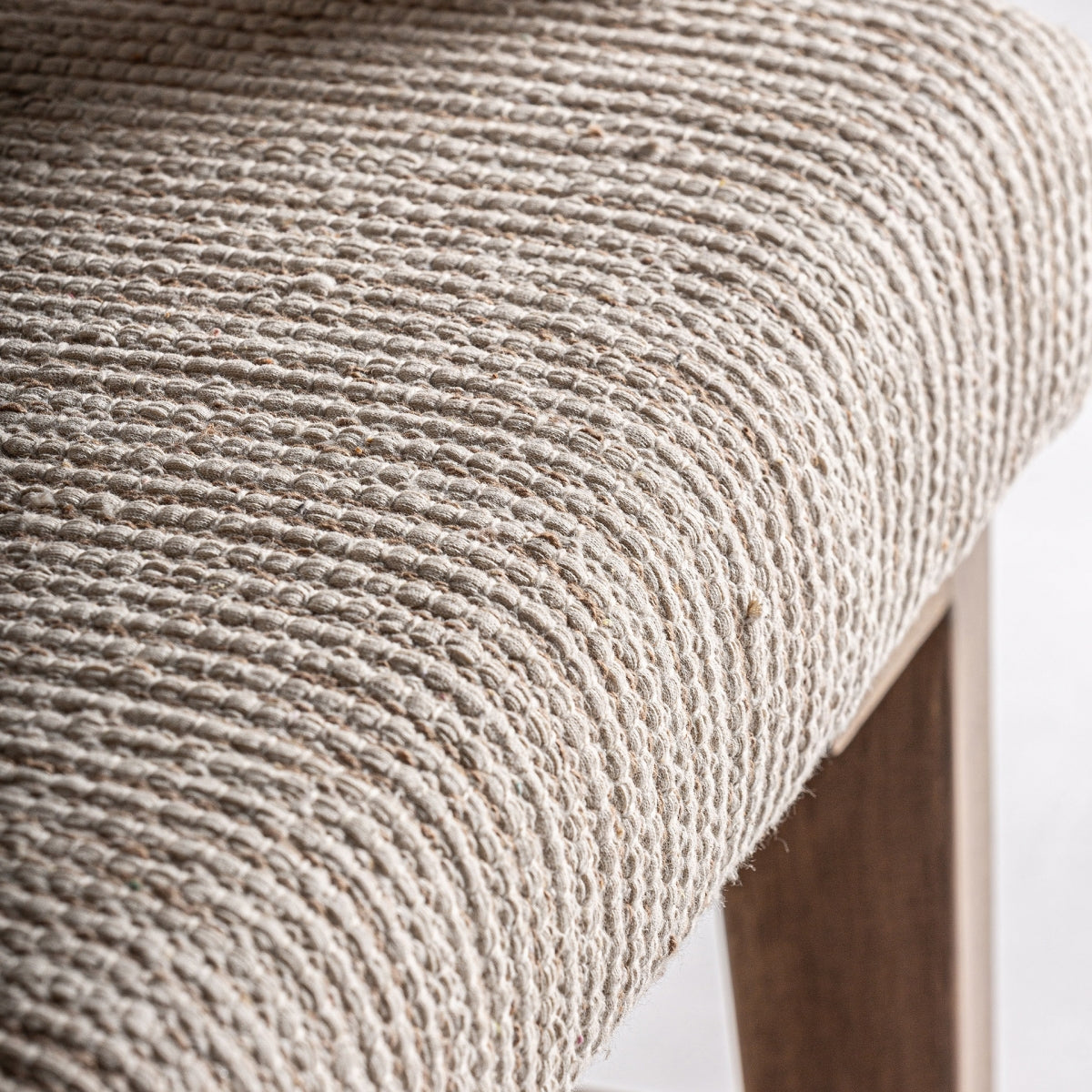 Detalle del tapizado en tejido de rayas beige natural de la butaca Romarand, textura suave y cálida