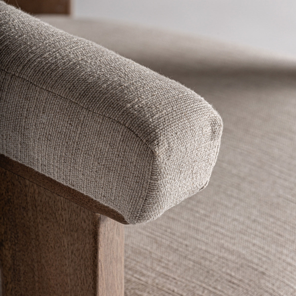 Primer plano del brazo del sillón tapizado en tejido rústico natural – detalle textil de calidad boutique interiorismo vical