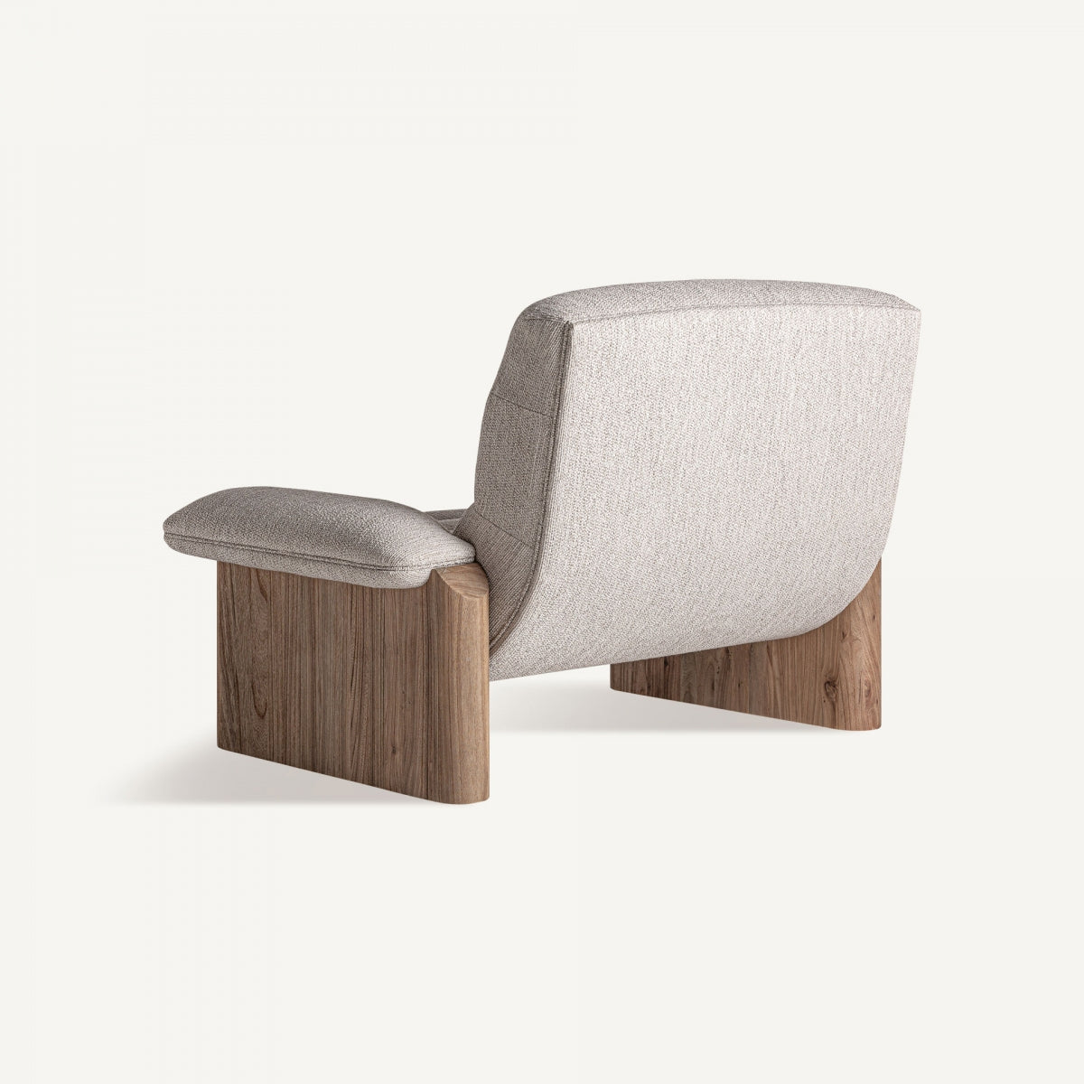 Vista trasera de butaca jacquard con respaldo envolvente y base en madera cálida