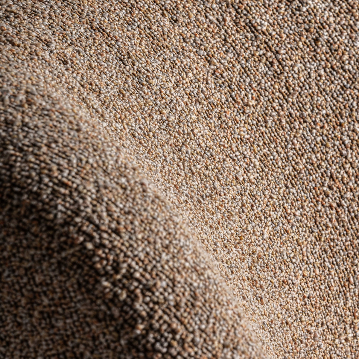 Textura del tejido bouclé visto de cerca en la superficie de la butaca Ibsen.