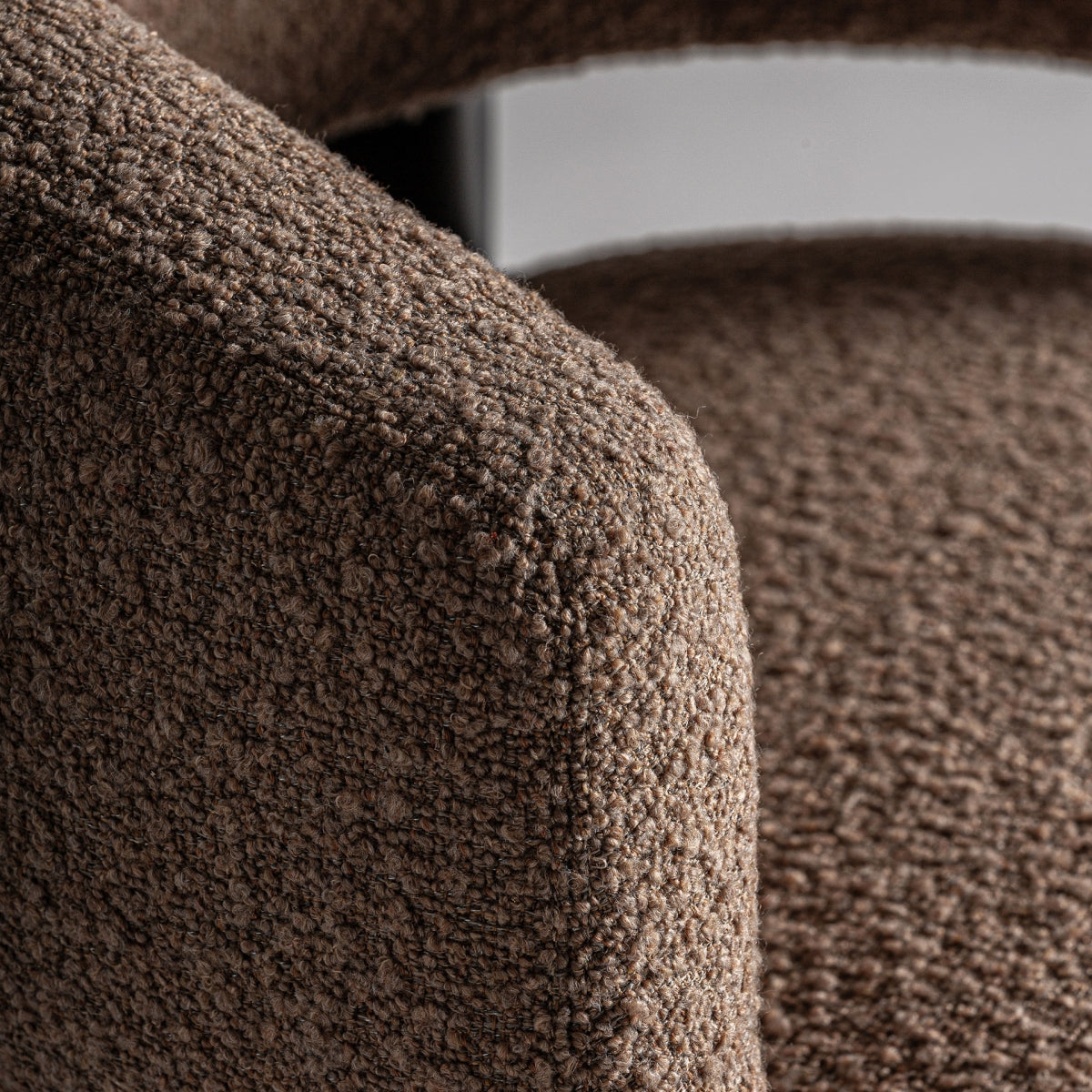 Detalle del brazo redondeado tapizado en bouclé marrón de la butaca IRVIN - boutique_interiorismo - vical