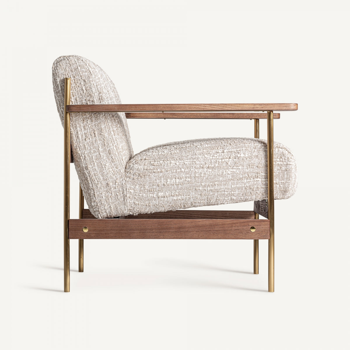 Vista lateral de butaca vintage con patas metálicas efecto latón y tapizado de textura suave.