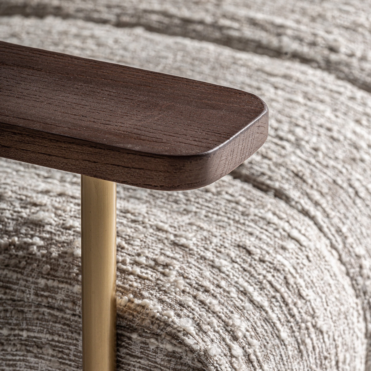 Primer plano del apoyabrazos de madera natural en butaca con diseño artesanal.