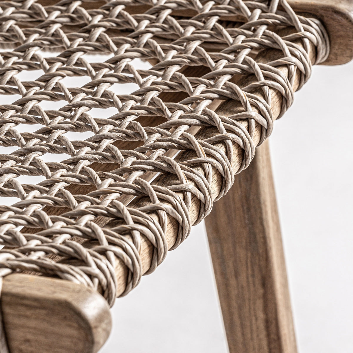 Enfocado en el encaje artesanal del asiento de cuerda trenzada sobre madera, técnica cuidada y decorativa.