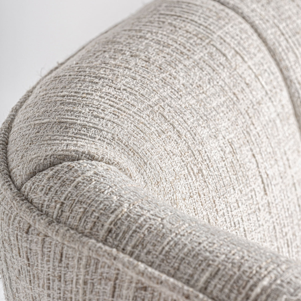Detalle cercano del tapizado en lino beige con textura marcada, confort y elegancia en ambientes neutros.
