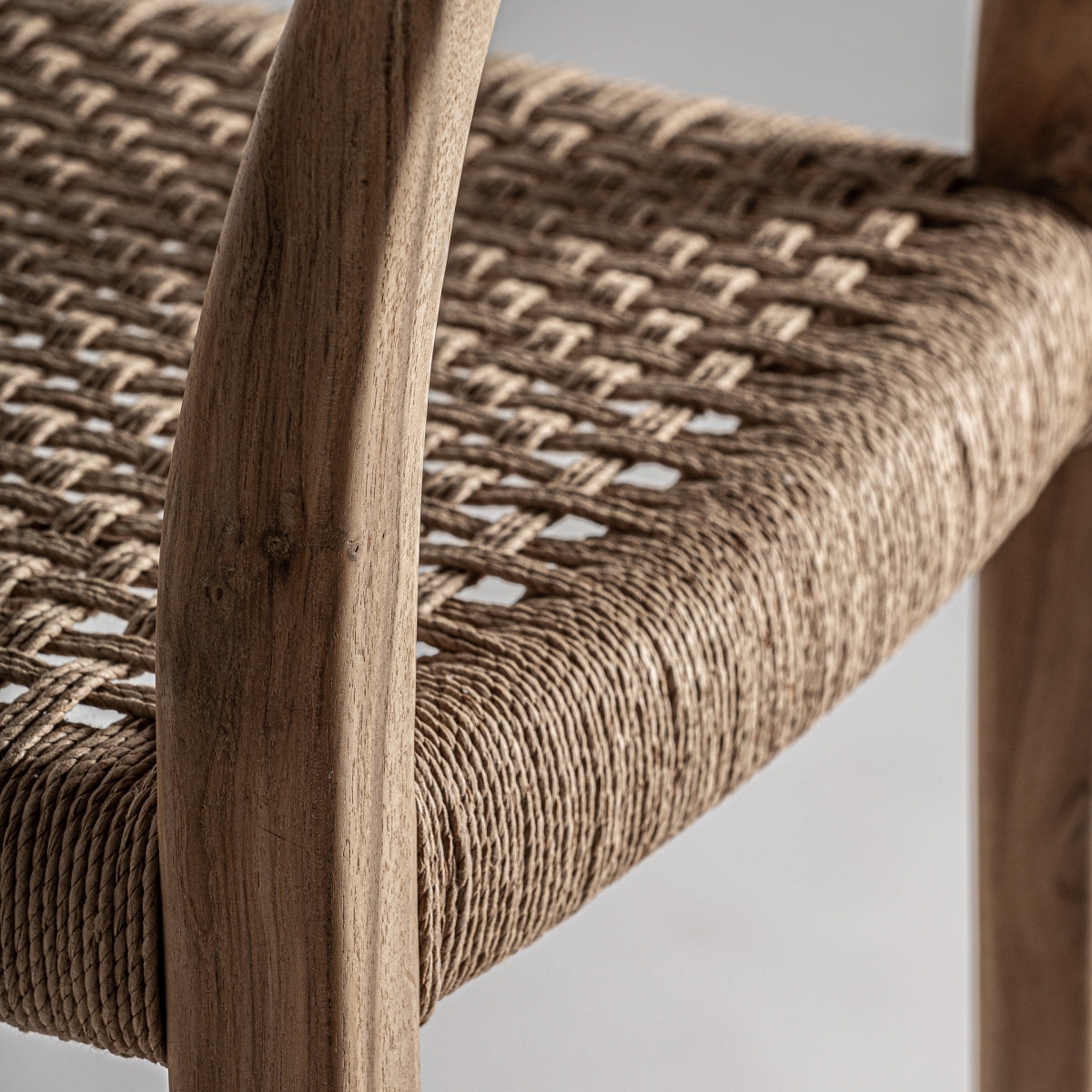 Vista detalle del respaldo curvado en madera natural, acabado suave y elegante