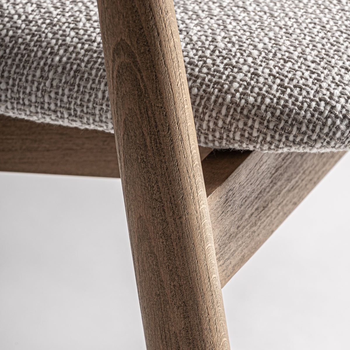Detalle del brazo del taburete tapizado en bouclé con textura suave y cálida.