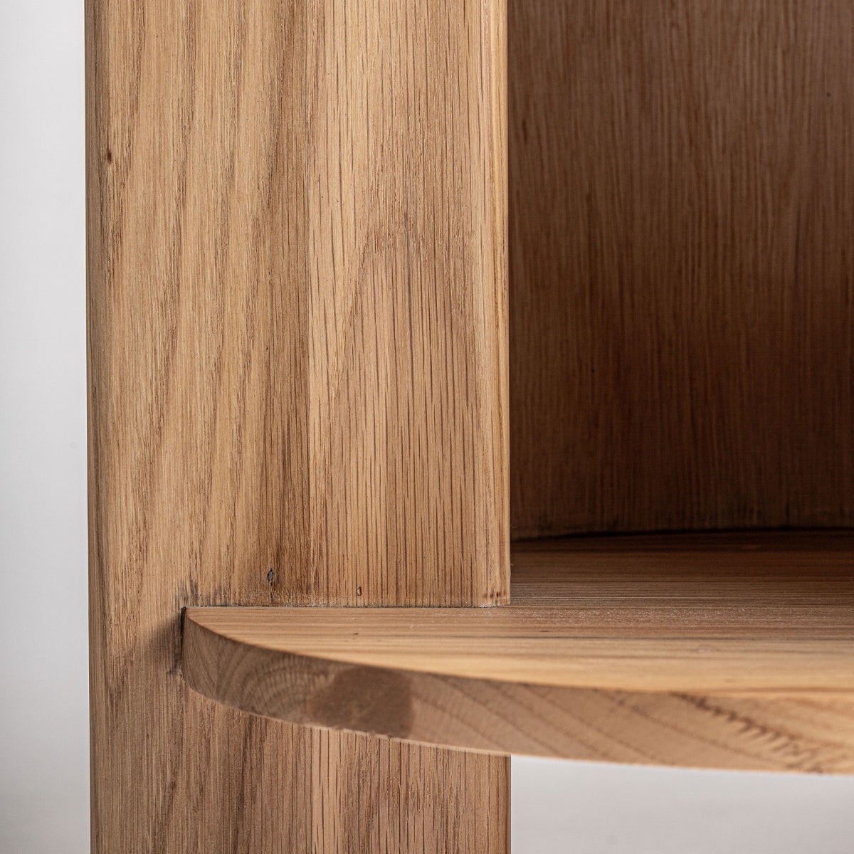 Detalle lateral del mueble bajo Nara, curvas suaves y líneas puras en roble natural para interiorismo contemporáneo